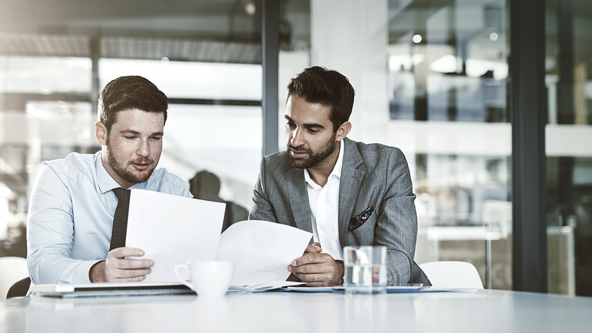 two people looking at papers
